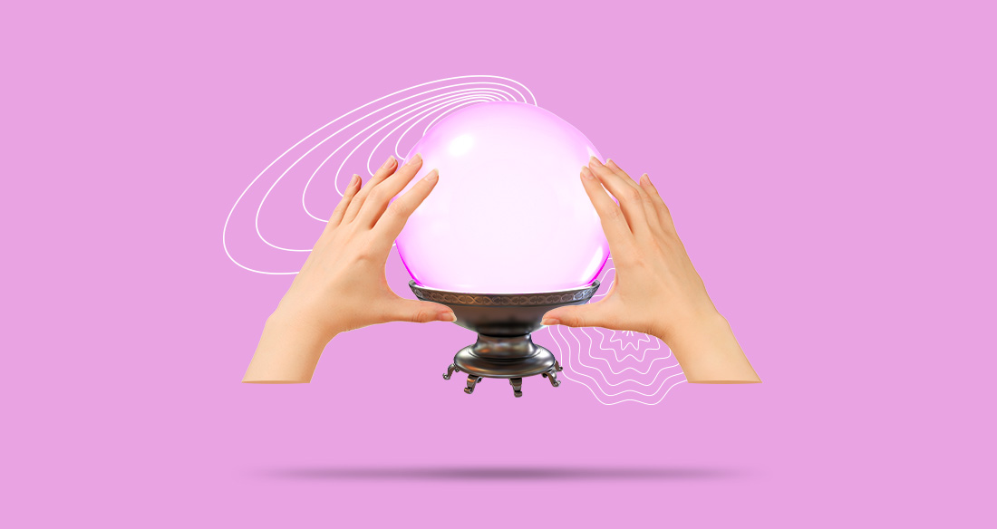 Two hands hovering over a crystal ball on a pink background.